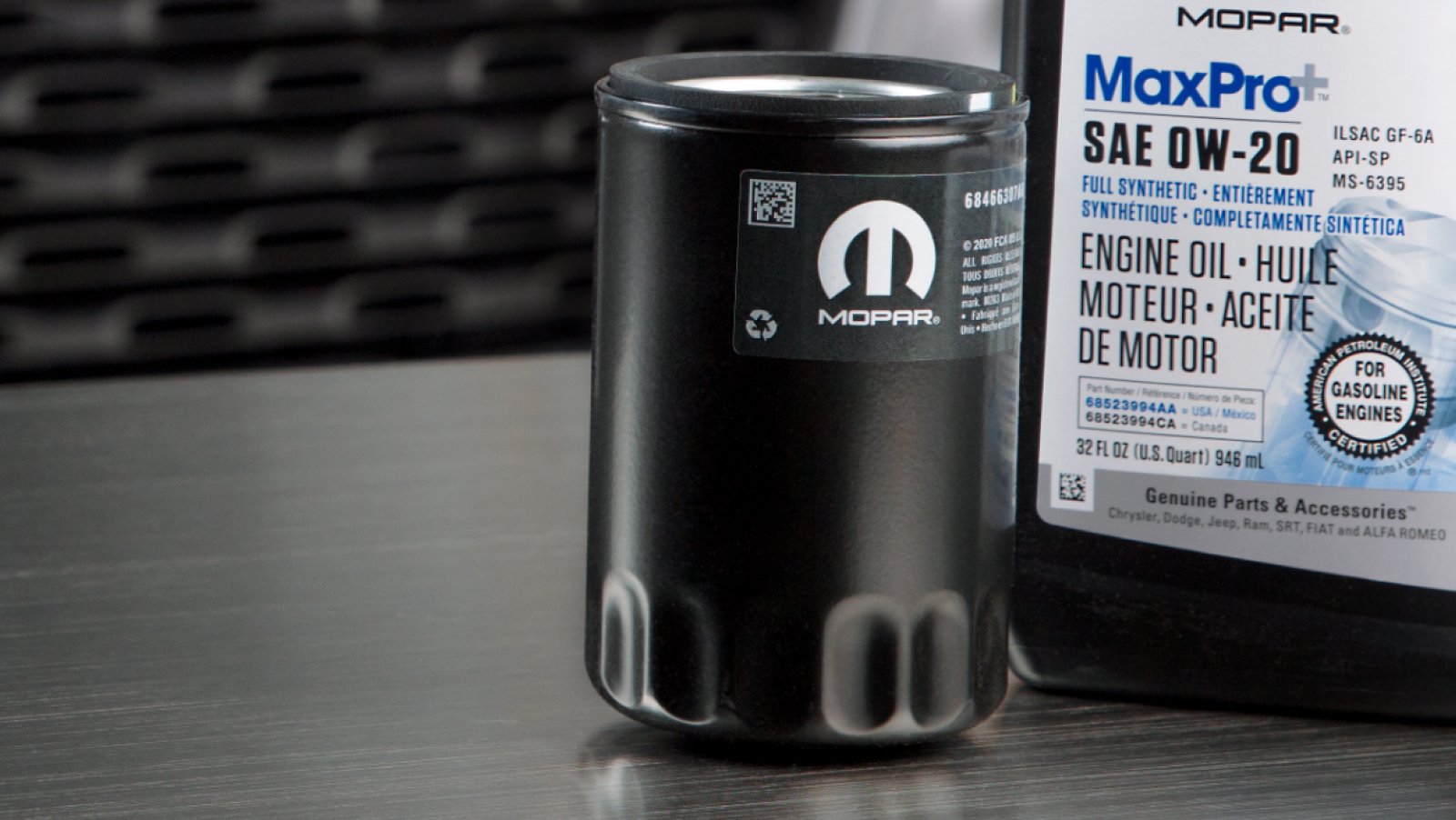 Mopar Engine Oil and filter sitting on a table in front of a Ram Truck