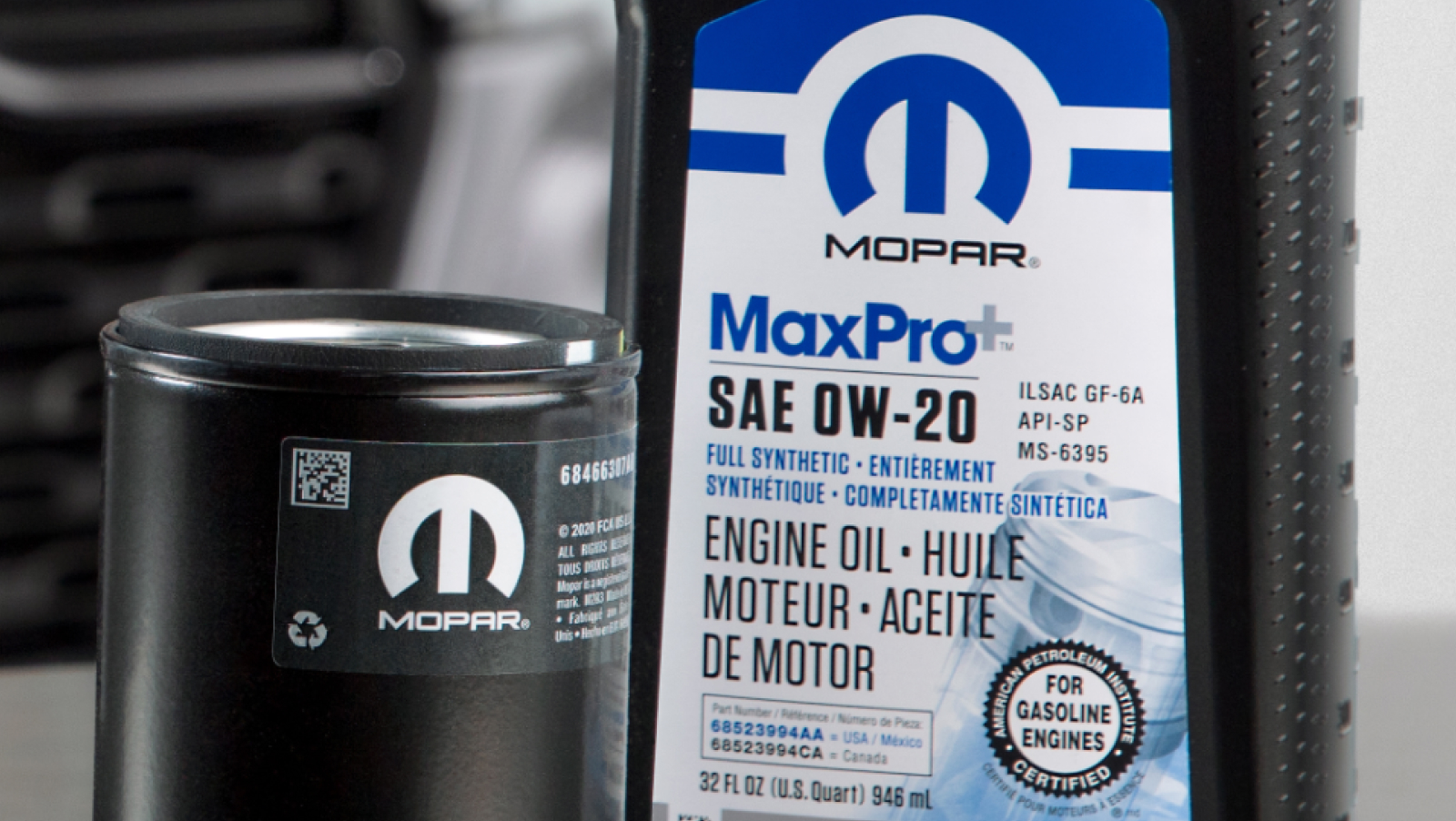 Mopar Engine Oil and filter sitting on a table in front of a Ram Truck