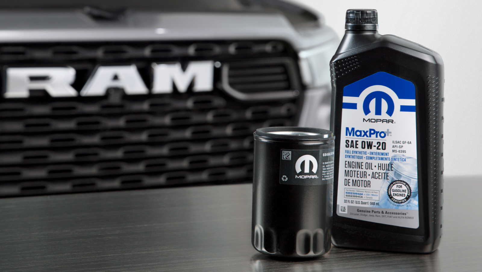 Mopar Engine Oil and filter sitting on a table in front of a Ram Truck