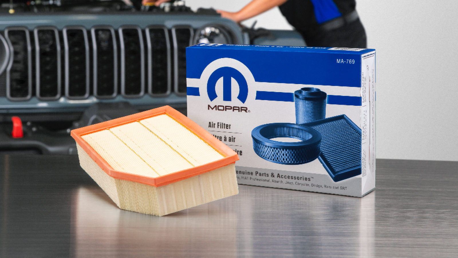 Mopar air filter on metal table in front of Mopar air filter box with part number and Jeep in the background