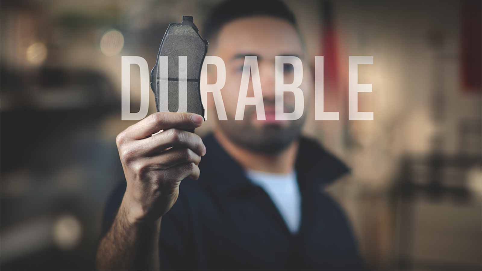 technician holding Mopar brake pad with the word DURABLE in white over the image