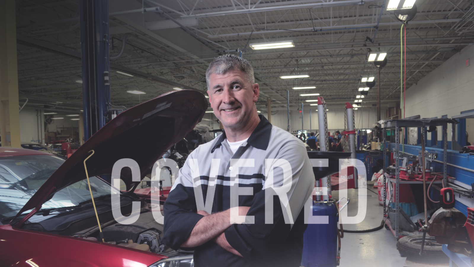 Mopar technician standing with arms crossed in front of a car with the hood open with the word COVERED in white over the image